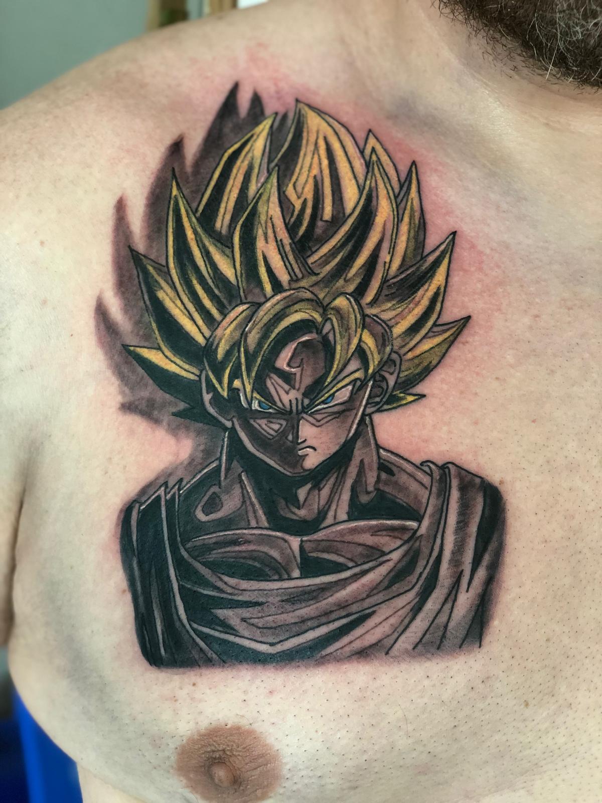 Tattoo van Goku met geel haar op de borst