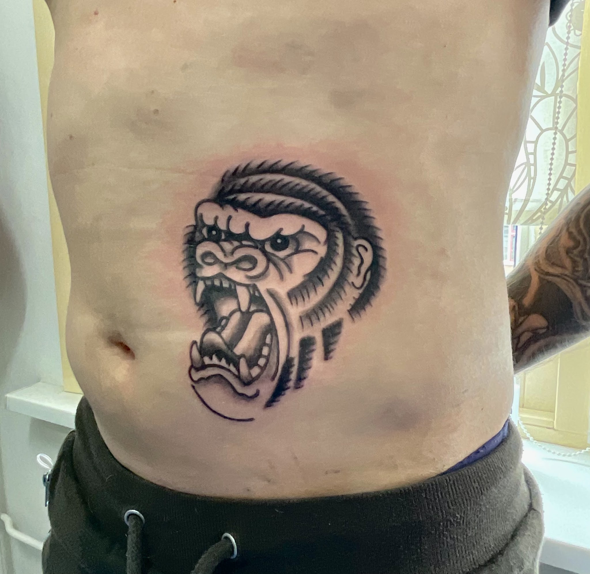 Tattoo van een brullende gorilla op de zij