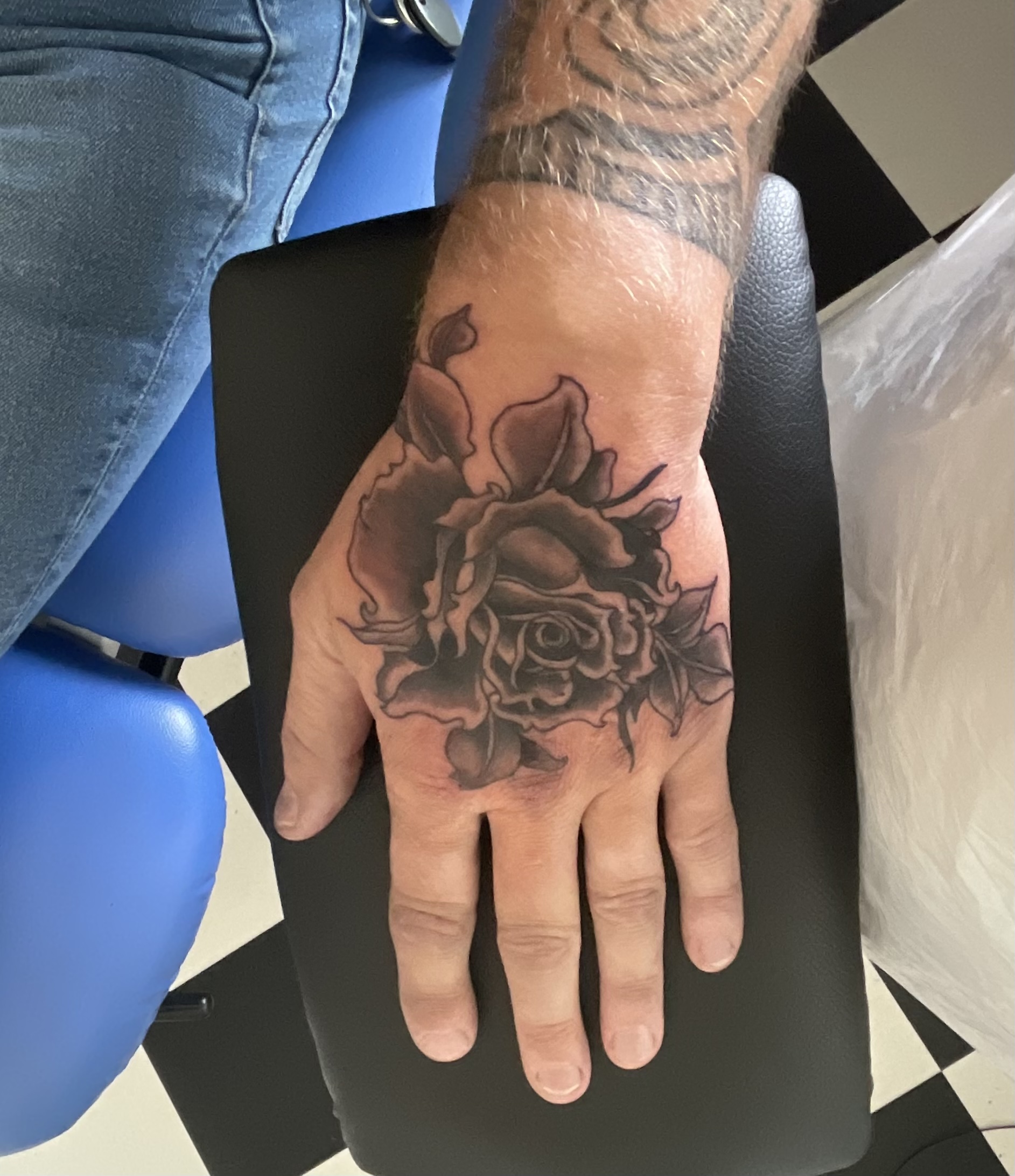Zwart-grijze roos op de rug van een hand